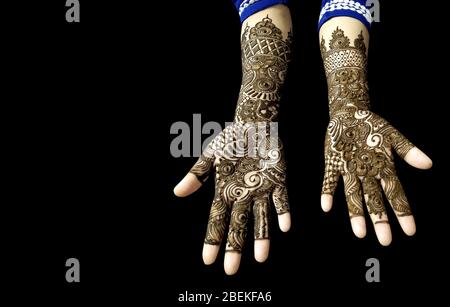 Schöne Mehendi Design auf Händen in schwarzem Hintergrund mit Kopierraum für Text Stockfoto