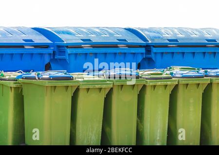 Große blaue und kleine grüne Abfallbehälter auf weißem Hintergrund isoliert Stockfoto