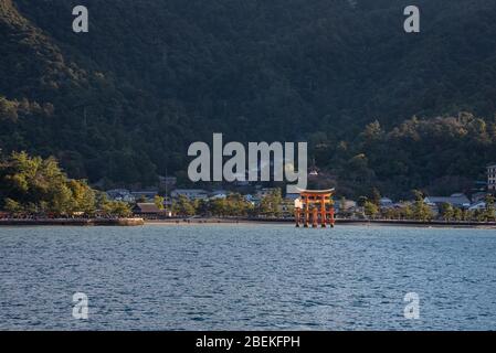 Blick auf die Insel Miyajima von der Fähre. Das schwimmende rote riesige Grand O-Torii Tor steht am Strand bei Ebbe an sonnigen Tagen in Hiroshima City Stockfoto