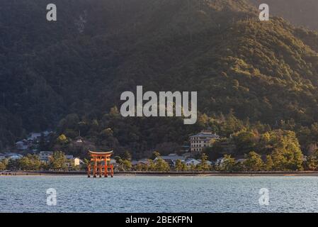 Blick auf die Insel Miyajima von der Fähre. Das schwimmende rote riesige Grand O-Torii Tor steht am Strand bei Ebbe an sonnigen Tagen in Hiroshima City Stockfoto