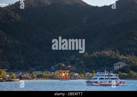 Blick auf die Insel Miyajima von der Fähre. Das schwimmende rote riesige Grand O-Torii Tor steht am Strand bei Ebbe an sonnigen Tagen in Hiroshima City Stockfoto