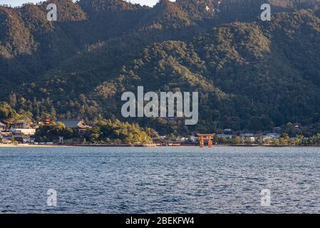 Blick auf die Insel Miyajima von der Fähre. Das schwimmende rote riesige Grand O-Torii Tor steht am Strand bei Ebbe an sonnigen Tagen in Hiroshima City Stockfoto