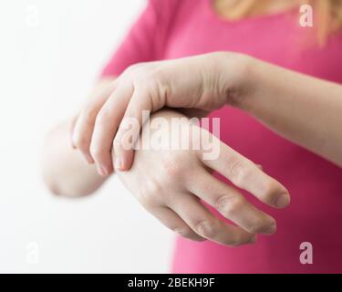 Junge Frau oder Mädchen mit rheumatoider Arthritis Krankheit deformierte Finger und Hände. Stockfoto