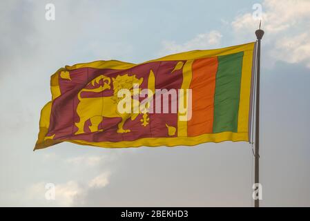 Die Nationalflagge Sri Lankas Nahaufnahme auf dem Hintergrund des Abendhimmels Stockfoto