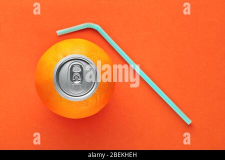 Orange Frucht mit Pop-up Silber Oberseite einer Dose und ein Stroh auf orangefarbenem Hintergrund. Frisches Orangensaft und Vitamine Konzept. Draufsicht. Stockfoto