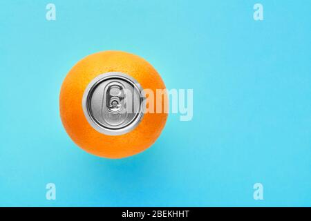 Orange Frucht mit Pop-up Silber oben auf einer Dose auf blauem Hintergrund mit Kopierraum. Draufsicht. Stockfoto