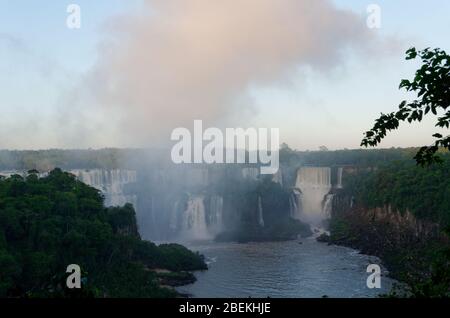 Nebel steigt in der frühen Morgendämmerung von den Iguacu Falls in Brasilien auf Stockfoto