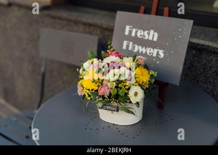 Schöner Hintergrund mit gelben Blumen an einem sonnigen Sommertag. Tisch und Dekoration eines Straßencafés in der Altstadt serviert. Stockfoto