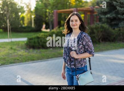 Mädchen Spaziergänge im Sommerpark. Brunette Mädchen in der Innenstadt Stockfoto