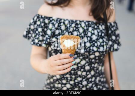 Joung Frau hält Vanilleeis in Kegel. Vanilleeis in einem Waffelzapfen Stockfoto