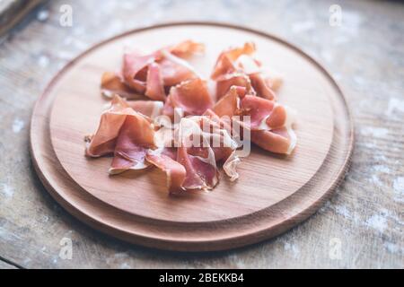 Prosciutto auf einem Holzteller. Fleischschnitt auf einem Holzbrett Stockfoto