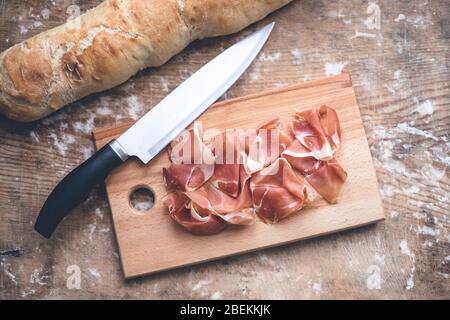 Spanischer Prosciutto, Baguette und Messer Stockfoto