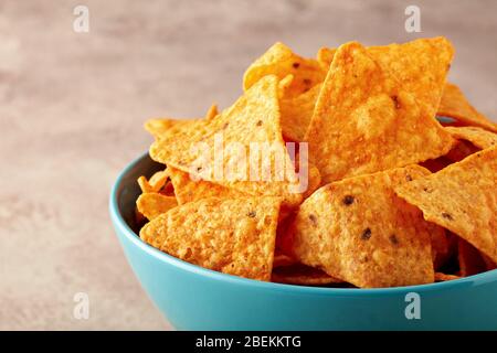 Mexikanische Nachos oder Tortilla Chips in einer türkisfarbenen Schüssel. Nahaufnahme. Stockfoto