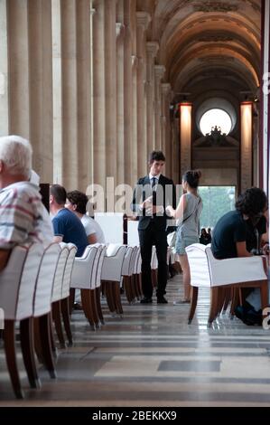 Paris, Frankreich - Juli 08 2008: Leute und Kellner in einem raffinierten Café in der Rue de Rivoli, das Le Café Marly, beim Louvre-Museum heißt Stockfoto