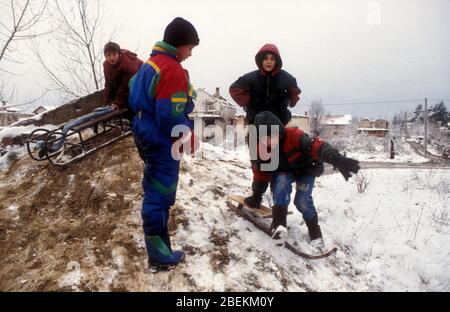 Sarajevo 1995 - Kinder spielen im Schnee in Wohngebiet, das von serbischen Bombenangriffen während der Belagerung von Sarajevo, Bosnien und Herzegowina getroffen wurde Stockfoto