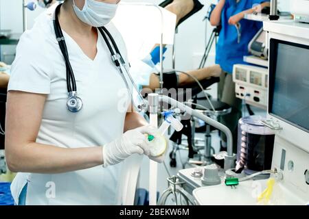 Ein Intensivarzt bereitet bei einem kritischen Patienten mit Coronavirus Geräte für die künstliche Beatmung der Lunge für die Intubation vor. COVID-19 Stockfoto