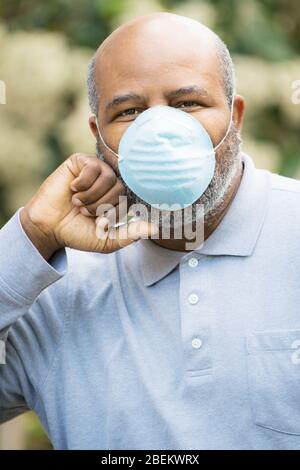 Coronavirus, Portrait des afroamerikanischen Mannes draußen mit Schutzmaske. Konzept der Lockdown, Flatten the Curve, Social Distancing, Zustand des Emerg Stockfoto