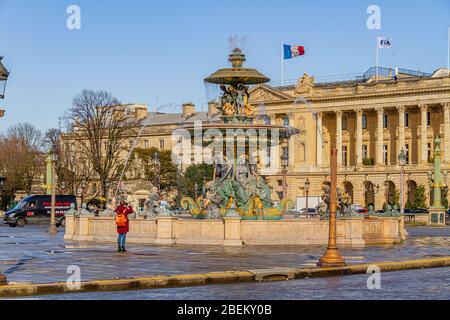 Ein Tourist, der die Fontaine des Fleuves und die Hôtel de la Marine auf dem Place de la Concorde, Paris, Frankreich, fotografiert. Februar 2020. Stockfoto