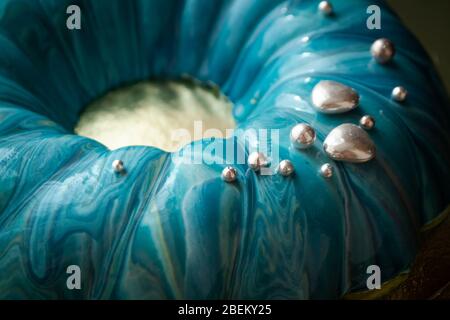 Trendige Mousse-Torte mit blau-türkisfarbener Spiegelglasur. Nahaufnahme Stockfoto