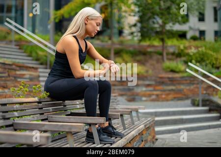 Fit Frau Einrichtung Fitness Smart Watch Gerät vor dem Laufen Stockfoto