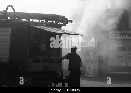 Die eigentliche Arbeit der Feuerwehrleute am Tatort. Löschen eines brennenden Gebäudes Stockfoto