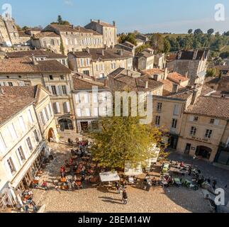 Blick über eine Café-Terrasse auf dem Place de I'Eglise Monolithe in Saint Emilion, Frankreich Stockfoto