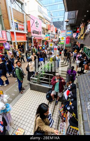 Tokio, Harajuku, Takeshita Straße. Blick von oben, Menschenmassen, die durch die schmale Fußgängerzone gehen, vorbei an der Attasgirl Fashion Boutique. Stockfoto