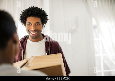 Fröhliches junges Paar zieht in ihr neues Zuhause Stockfoto