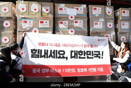 (200414) -- PEKING, 14. April 2020 (Xinhua) -- Mitarbeiter der Roten Kreuz Gesellschaft von Südkorea präsentieren ein Banner mit unterstützender Botschaft, nachdem sie chinesische medizinische Versorgung auf einem Fahrzeug in Inchon, Südkorea, 20. März 2020 geladen hatten. ZU DEN XINHUA SCHLAGZEILEN VOM 14. APRIL 2020. (NEWSIS/Handout über Xinhua) Stockfoto