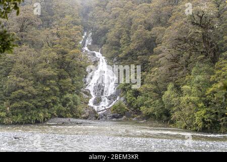 Landschaft mit Wasserfällen im grünen Wald am Haast River, aufgenommen im hellen Frühling bewölktes Licht bei Fantail Falls, Westküste, Südinsel, Neuseeland Stockfoto