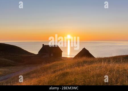 Zwei Fischerhütten bei Sonnenaufgang im Sommer entlang der Ostseeküste bei Havaeng / Haväng, Österlen / Oesterlen, Skane / Scania, Schweden Stockfoto