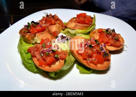 Teller mit gemischter Bruschetta auf grünem Salat, Beschichtung von italienischen Fingerfood, gesunde Snack zum Brunch oder Vorspeise aus Italien, hausgemachte lecker o Stockfoto