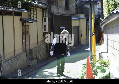 Kyoto, Japan. April 2020. Resident mit Gesichtsmaske reinigt seine Umgebung in Kyoto am Dienstag, 14. April 2020, inmitten der Ausbreitung des neuen Coronavirus. Der japanische Premierminister Shinzo Abe erklärte vergangene Woche Tokio und sechs anderen Präfekturen, darunter Kyoto, zum Ausnahmezustand, um die Abwehr gegen die Ausbreitung des Coronavirus zu verstärken. Kredit: Aflo Co. Ltd./Alamy Live News Stockfoto