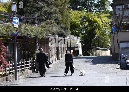 Kyoto, Japan. April 2020. Resident mit Gesichtsmaske geht am Dienstag, den 14. April 2020, mit ihrem Hund in Kyoto durch die Ausbreitung des neuen Coronavirus. Der japanische Premierminister Shinzo Abe erklärte vergangene Woche Tokio und sechs anderen Präfekturen, darunter Kyoto, zum Ausnahmezustand, um die Abwehr gegen die Ausbreitung des Coronavirus zu verstärken. Kredit: Aflo Co. Ltd./Alamy Live News Stockfoto