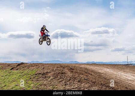 Dacono, CO/ USA- 29. März 2020 Motocross-Fahrer fahren um die Strecke und schlagen Sprünge und Berms in Colorado's Front Range Stockfoto