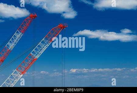 Bauindustrie und Entwicklung. Zwei Kraniche bei der Arbeit zwischen Wolken (mit Kopierraum) Stockfoto