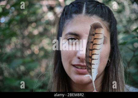 Ein Porträt einer Frau mit einer Vogelfeder Stockfoto