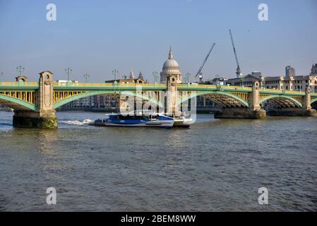 London, Großbritannien - 15. April 2019: Thames Clipper Boot unter der Southwark Bridge mit St Paul's Cathedral im Hintergrund Stockfoto