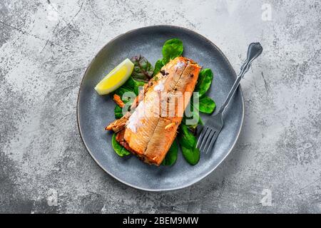 Draufsicht auf Teller mit rotem Lachs im Ofen mit Gewürzen gebacken Stockfoto