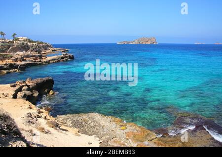 Blick von der Südküste Ibizas auf den Inselfelsen Es Vedra. Schöne Landschaft mit Klippen & türkisfarbenem Wasser. Baleric-Inseln, Spanien. Stockfoto