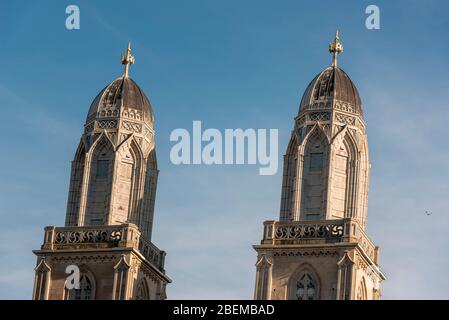 Zwei mittelalterliche Kirchtürme gegen einen klaren blauen Himmel in der Altstadt von Zürich, Schweiz. Schweizer Grossmünster-Dom steht am Morgen Stockfoto