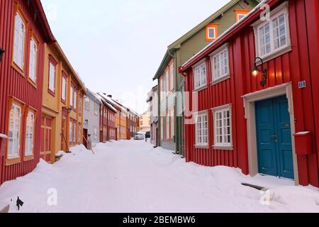 Bunte traditionelle Häuser entlang einer schneebedeckten Straße im Zentrum der historischen Bergbaustadt Røros, Norwegen. Stockfoto