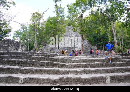 COBA MAYA RUINEN, Mexiko - Besucher steigen Steintreppen in La Iglesia (die Kirche), eine der größeren Strukturen in Coba Stockfoto