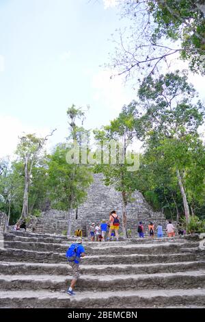 COBA MAYA RUINEN, Mexiko - Besucher steigen Steintreppen in La Iglesia (die Kirche), eine der größeren Strukturen in Coba Stockfoto