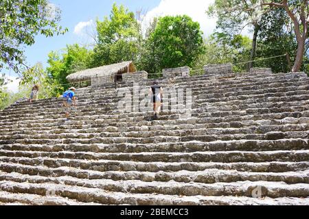 COBA MAYA RUINEN, Mexiko - Besucher steigen Steintreppen in La Iglesia (die Kirche), eine der größeren Strukturen in Coba Stockfoto