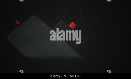 Art Foto Banner Smartphone Aufladen mit einem tragbaren Ladegerät - Power Bank. Das Konzept der modernen Autonomie mobiler Geräte. Stockfoto