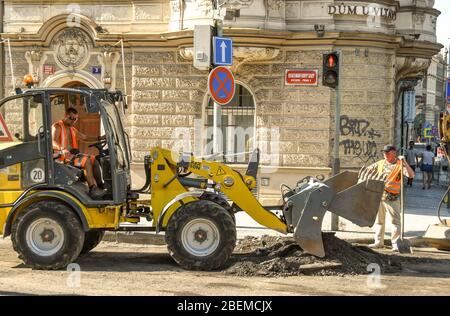 PRAG, TSCHECHISCHE REPUBLIK - JULI 2018: Traktorabschleppteppich von der Straßenoberfläche in der Prager Innenstadt entfernt. Stockfoto
