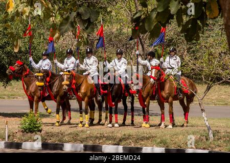 Chandigarh / Indien / 04. April 2017: Reitergruppe auf Pferden mit blauem und rotem Fack in der Sonne Stockfoto