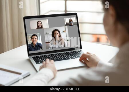 Frau sitzt am Schreibtisch mit Laptop und Videoanruf Stockfoto