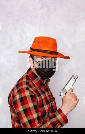 Porträt eines Cowboys mit Maske und Pistole. Amerikanischer Bandit in Maske, westlicher Mann mit Hut. Stockfoto